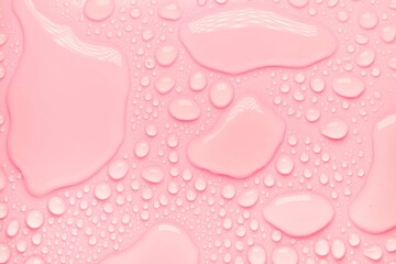 Cosmetic moisturizing liquid drops on pink pastel background. Toner or lotion. Hyaluronic serum
