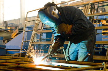 Fototapeta premium A welder works at a factory