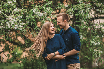 Fototapeta premium Portrait of a happy couple have fun in the spring garden. Strong family relationships of a couple in love