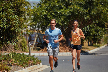 Naklejka premium The only bad workout is the one you didnt do. Shot of a happy couple jogging together in their neighborhood.