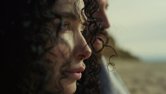 Hispanic woman face looking blowing wind. Couple enjoying sea beach landscape.