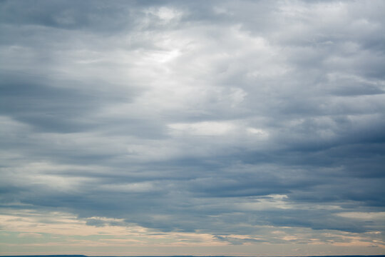 Cloudscape before rain background. Clouds pattern. Heavy hanging clouds high in the sky.