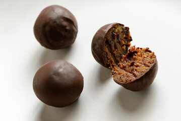 sliced ​​vegan chocolate candy with figs and prunes on a white plate, close-up