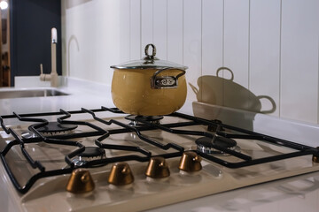 Beige cooking pot on the gas stove in traditional kitchen interior