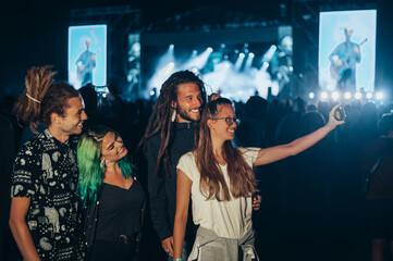 Friends at summer music festival taking selfie with a smartphone