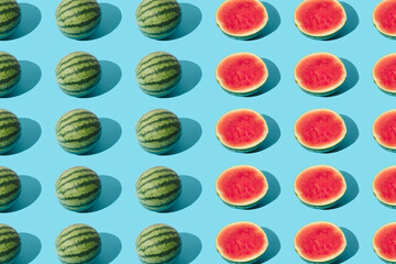 Arranged watermelon and the half on a blue pastel background. Minimal pattern and design.