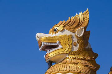 Golden stone statue of a lion in a Buddhist temple in Myanmar, Burma