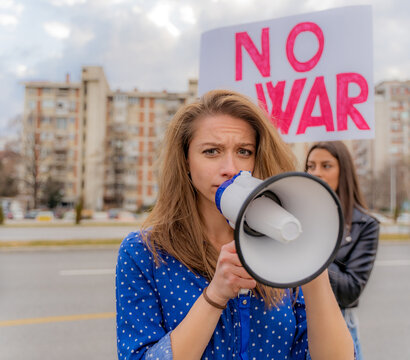 Sad girl talking on the megaphone while crying, close up