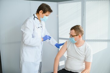Obraz premium Close up of a Doctor making a vaccination in the shoulder of patient, Flu Vaccination Injection on Arm, coronavirus, covid-19 vaccine disease preparing for human clinical trials vaccination shot.