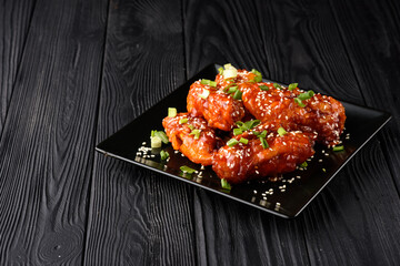 Korean fried chicken with black backdrop.