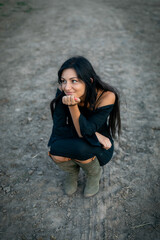 Girl with long black hair in the countryside. Ipadrome with horses. Rural landscapes, wild west.