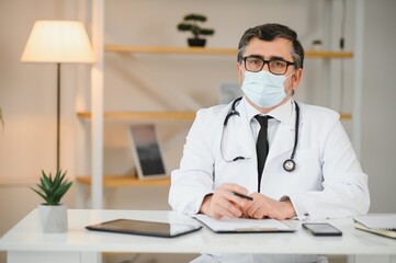 male doctor with medical face mask and a stethoscope at clinic.