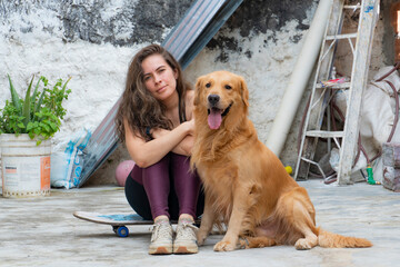 posing with golden retriver pet in casual sporty backyard