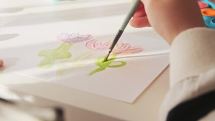 Kids hands drawing flowers picture with paints and brush. Concept child hobby creative art activity, online education.