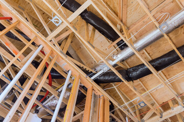 A new building under construction with installation of HVAC tubing vents heating system on the attic