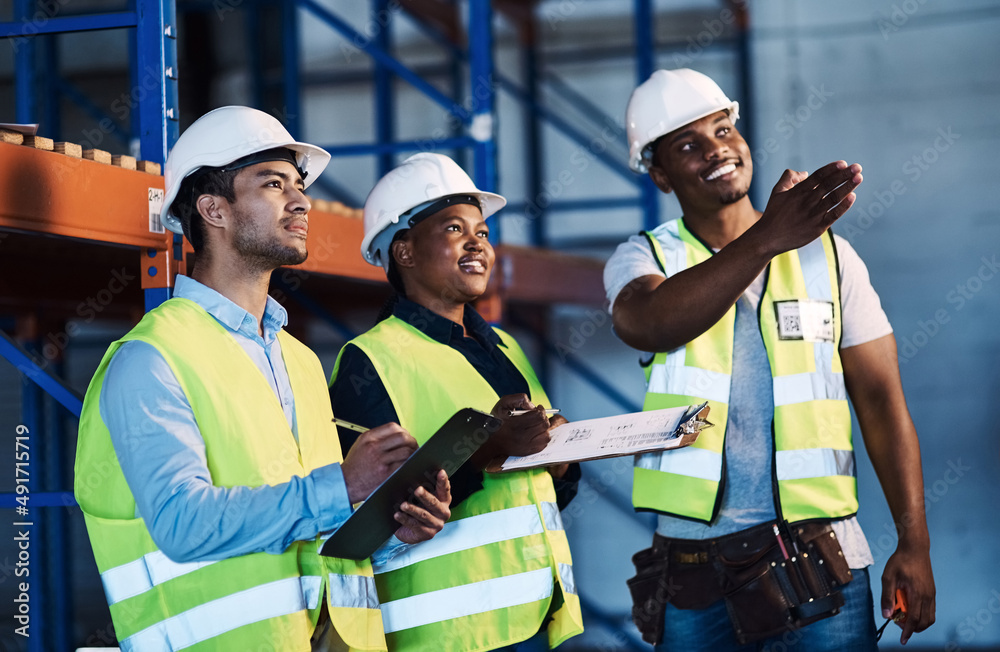 Poster this just came in. shot of a group of contractors standing in the warehouse and looking contemplativ
