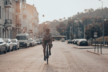 Naklejka premium Man in sport clothes riding black bike on city street
