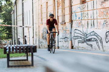 Caucasian man in sport clothes riding black bike outdoors