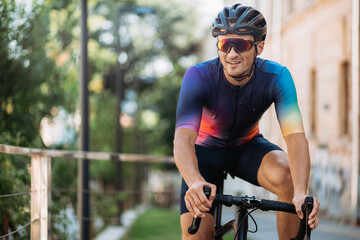 Happy cyclist sitting on black bike among city street