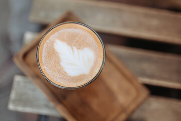 Coffee drink with beautiful latte art served on wooden table