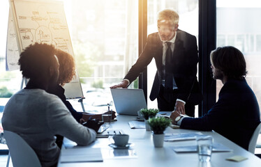 Strategizing in the boardroom. Shot of a mature businessman giving a presentation to colleagues in a boardroom.