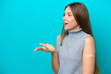 Young Lithuanian woman wearing band aids isolated on blue background with surprise facial expression