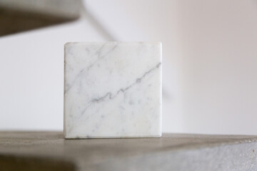 Carrara marble cube on a concrete step block; copy space composition