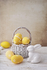 basket with colorful easter eggs and spring flowers