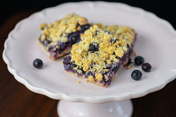 blueberry crumb bars on white antique plate