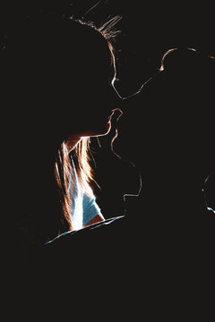 Silueta de pareja abraz&aacute;ndose y bes&aacute;ndose en la noche de la ciudad.
