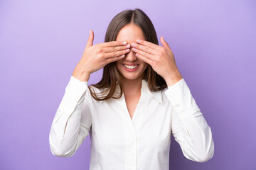 Young caucasian woman isolated on purple background covering eyes by hands and smiling