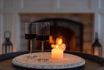 Two glasses of red wine by a cozy fire