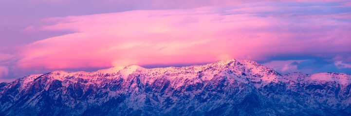Pink and purple sunset over snow-covered mountains near Salt Lake City, Utah