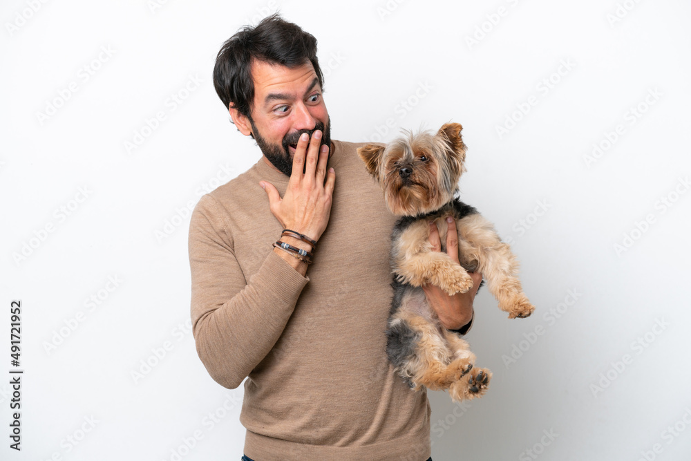 Wall mural Man holding a yorkshire isolated on white background with surprise and shocked facial expression