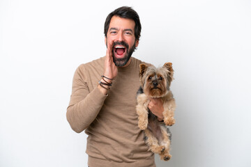 Man holding a yorkshire isolated on white background shouting with mouth wide open