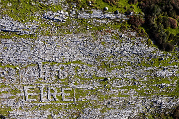 Aerial view on sign Ireland in Irish language EIRE made out of rocks in Burren area. West of Ireland. Popular travel region on Wild Atlantic Way known for it rock surface.