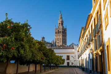 The famous Giralda, the bell tower of Seville Cathedral, built as the minaret for the Great Mosque of Seville in 12th century Moorish Spain: from Plaza Patio de Banderas, Sevilla, Andalusia, Spain