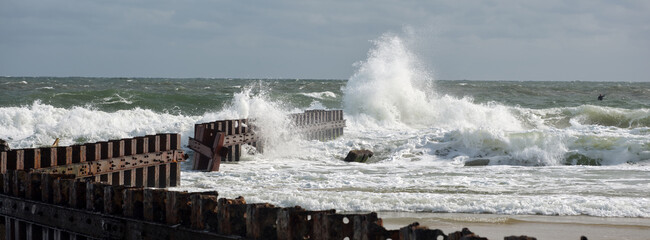 Panoramic image of heavy surf pounding the rusting sea wall where the Cape Hatteras lighthouse was...