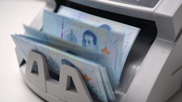 Thai Baht money counting in Machine. Paper THB Thai baht banknotes. Fast cash note count in Machine Counting. Business and economy in Thailand concept.