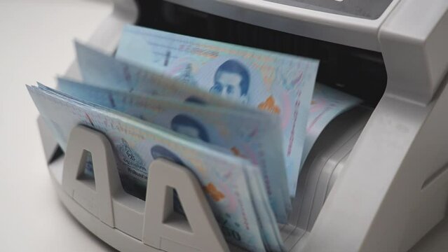 Thai Baht money counting in Machine. Paper THB Thai baht banknotes. Fast cash note count in Machine Counting. Business and economy in Thailand concept.