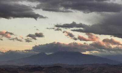 Nuvole colorate sopra la cima dei monti e le valli