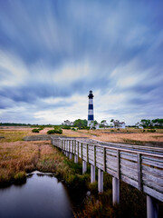 Vertical image of the Bodie Lighthouse and a wooden pier on a winter day