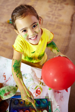 Wanna see me make magic with paint. Shot of an adorable little girl making a mess while painting.