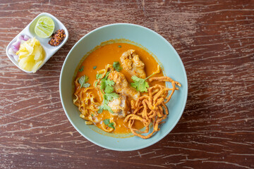 Thai Curry Noodles with Chicken in Thai when we call Khao Soi and Thai spicy egg noodle on wooden table.