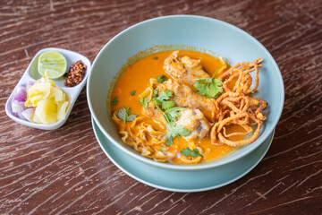 Thai Curry Noodles with Chicken in Thai when we call Khao Soi and Thai spicy egg noodle on wooden table.