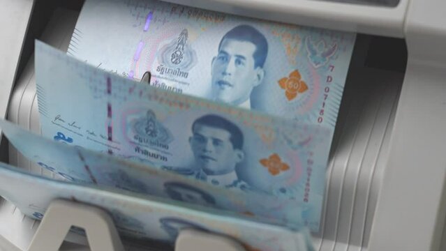 Slow Motion Shot of Thai Baht money counting in Machine. Paper THB Thai baht banknotes. Fast cash note count in Machine Counting. Business and economy in Thailand concept.