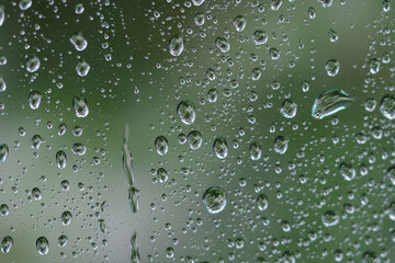 Close-up on water drops on glass under the rain.
