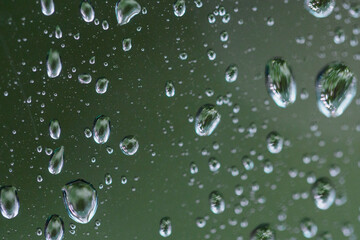 Close-up on water drops on glass under the rain.