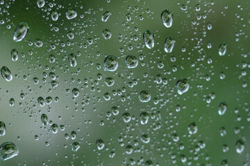 Close-up on water drops on glass under the rain.