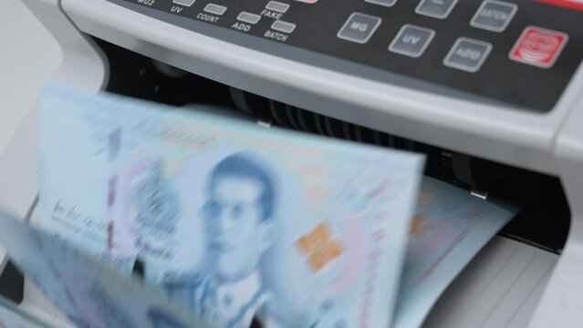 Slow Motion Shot of Thai Baht money counting in Machine. Paper THB Thai baht banknotes. Fast cash note count in Machine Counting. Business and economy in Thailand concept.